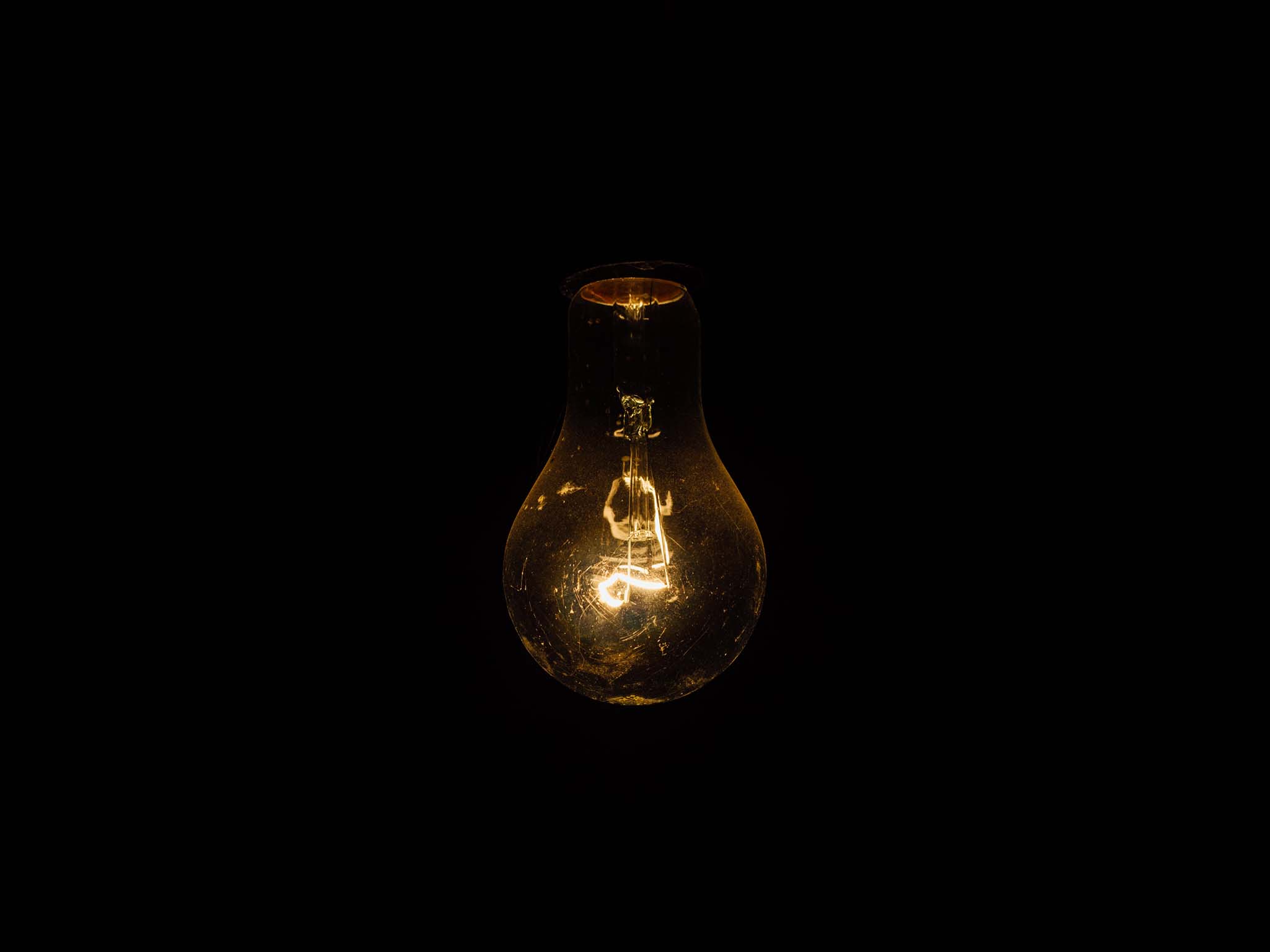 Glowing light bulb on black background.